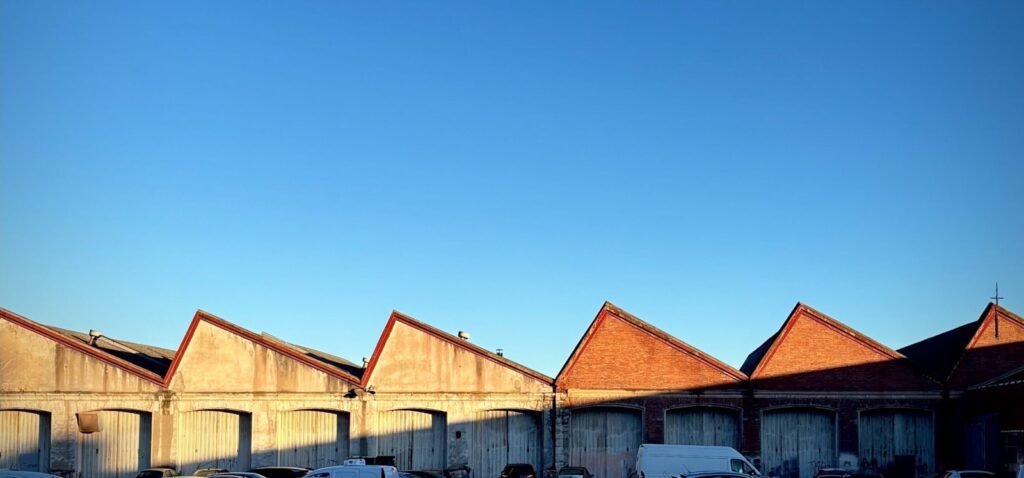 Row of industrial warehouse buildings with red roofs