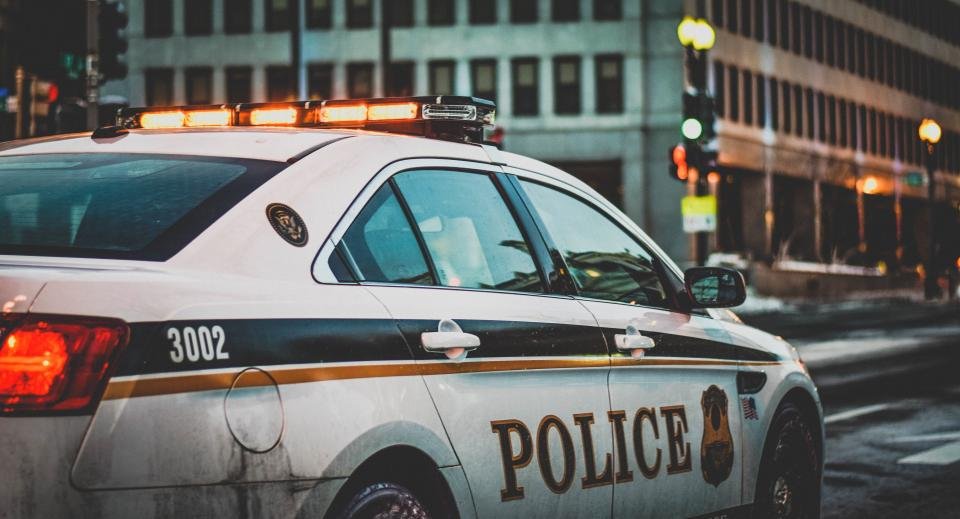 Police cruiser parked on a city street at dusk